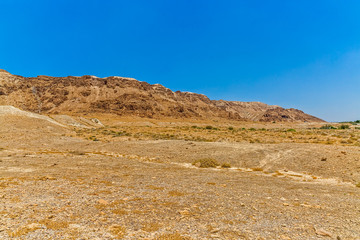 Israelis dry and sandy stone desert landscape by the Dead sea.