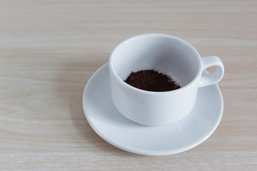 coffee powder in cup waiting for fill the hot water on wooden background