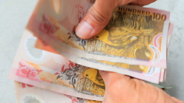 hand counting nzd dollars bank note