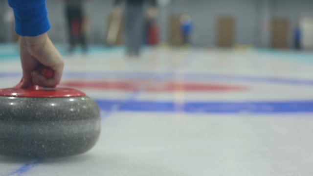 The player rolls a curling stone