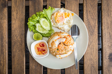 Fried rice with shrimps and fried egg. Decoration with cucumber,