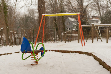 Ein Federgerät - Schaukelpferd - im Schnee auf einem Spielplatz