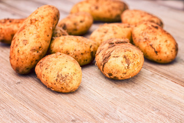 Raw potatoes on an old wooden board