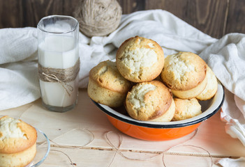 glass of milk with muffins on wooden table