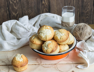 glass of milk with muffins on wooden table