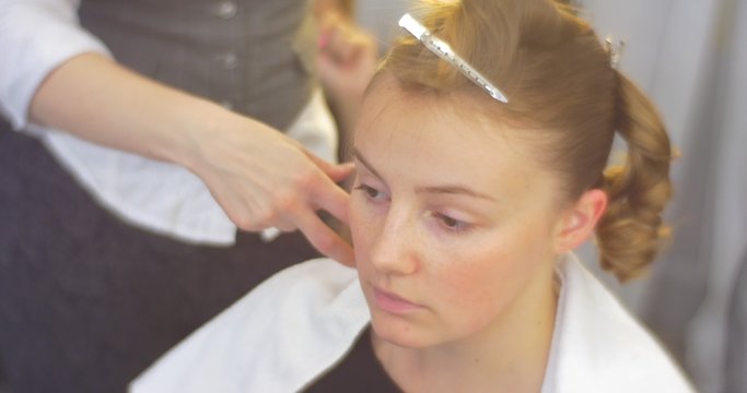 Stylist Hairdresser is Making The Hairstyle Curls and Fixing them on Woman Back of the Head Model's Forelock Fixed by Barrette Barbershop Beauty Salon