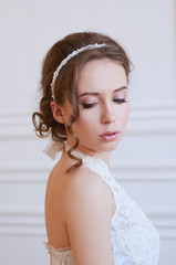 Bridal hairstyle and makeup. Young woman wearing headpiece.