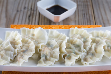 Chinese boiled pork and shrimp dumplings with soy sauce.