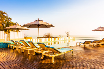 Umbrella and chair around swimming pool