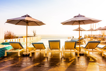 Umbrella and chair around swimming pool