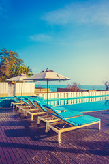 Umbrella and chair around swimming pool