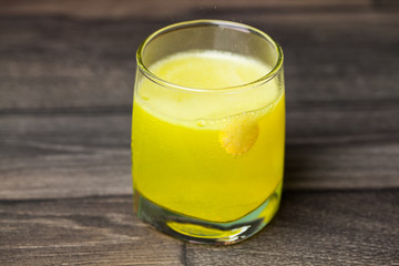 Glass with tablet in water with bubbles on wooden background