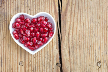Pomegranate seeds in heart shaped bowl