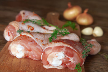 Raw chicken legs on wooden board.
