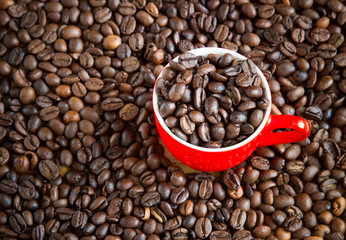 red cup of coffee on beans
