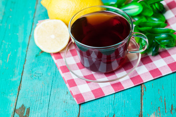 Cup of tea with lemon and honey on wooden background