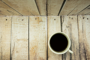 Black coffee cup isolated on wooden background.