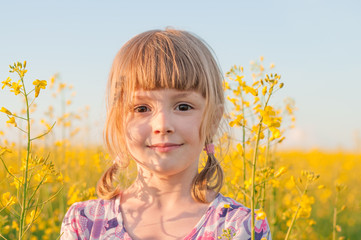 Girl with pigtails in a field of yellow flowers