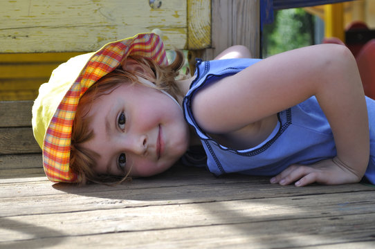 Little girl lying on a wooden board