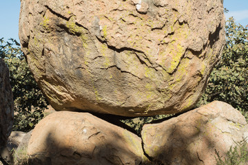 Piedra muy grande apoyada sobre dos piedras más chicas.