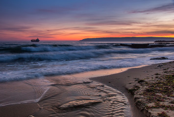 Sea after sunset. Beauty sea beach with slow shutter and waves flowing out.