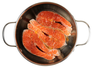 Salmon steaks being marinated in pot, isolated