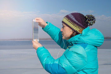 Smiling woman uses a tablet pc, making photo