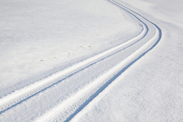 Car tire track on winter road