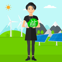 Woman holding lightbulb with windmills inside.