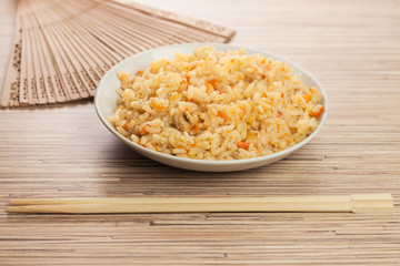 bowl of rice with chopsticks and fan