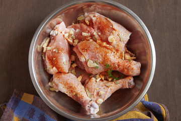 Chicken legs raw. On a dark wooden table.