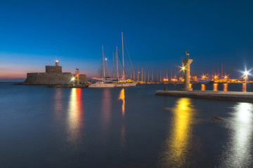 Fortress of St. Nicholas and sculpture Rhodes deer and deer at dawn. Rhodes Island. Greece