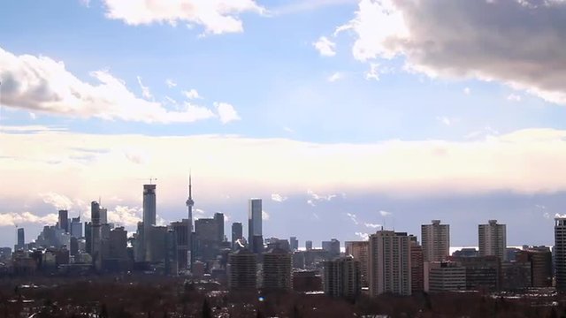 Toronto Downtown landmark buildings and skyscrapers under moving clouds in blue sky, view from midtown. 4k Time lapse with lattest newly built towers