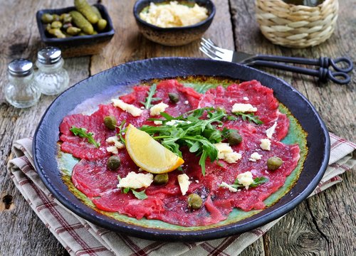 beef carpaccio with capers, parmesan, arugula, lemon and olive oil.
