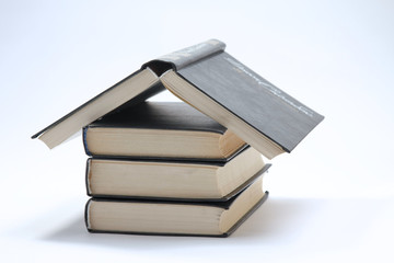 House made with books piled on white background