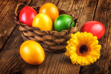 Obraz na płótnie Canvas Easter eggs basket on dark wooden background, sunlight effect