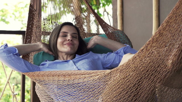 Young woman yawning and wake up after a nap on hammock on terrace, super slow motion, shot at 240fps
