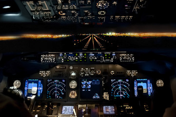 Final approach at night - landing plane flight deck view