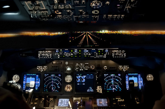 Fototapeta Final approach at night - landing plane flight deck view