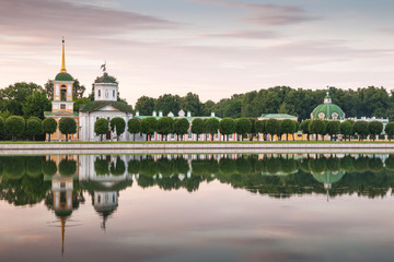 Church, bell tower and reflection in pond at sunset  in Kuskovo estate, Moscow, Russia. - obrazy, fototapety, plakaty