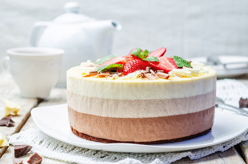 three chocolate cake decorated with strawberries and mint leaves