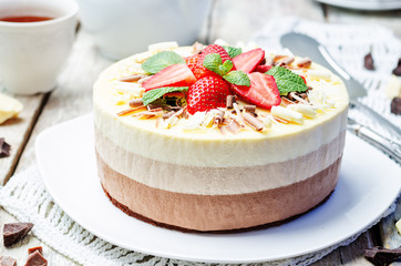 three chocolate cake decorated with strawberries and mint leaves