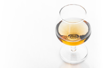 The cognac glass with golden brown alcohol inside.