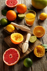 Citrus fruits with juicer on a grey wooden table