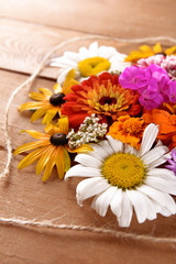 Fototapeta na wymiar Fresh colorful flowers on wooden table, closeup
