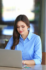 Fototapeta premium Young woman working with laptop in cafe