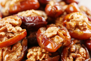 Walnut and date fruit on wooden table, close-up