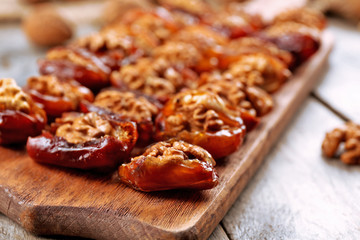 Walnut, date fruit on wooden table, close-up
