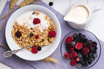 Muesli with yogurt and fresh berries in a ceramic bowl, top view