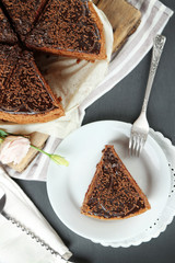 Sliced chocolate cake on plate, on wooden table  background